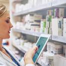 Pharmacist taking inventory with a tablet