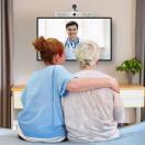 Healthcare worker and patient watching doctor on screen