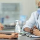 Healthcare worker showing tablet to others