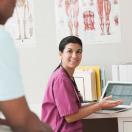 Healthcare worker with laptop talking to patient