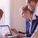 Group of businesspeopl looking at a laptop