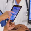 Healthcare workers looking at a medical record on a tablet