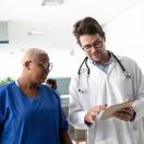 Doctor showing tablet to healthcare worker