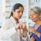 Pharmacist assisting senior customer.