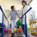 Healthcare worker working with child in physical therapy room