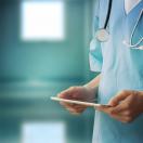 A medical professional using a tablet.