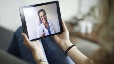 Female doctor on tablet for a telehealth visit