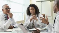 Doctors and informatics leaders speak at a table