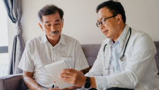 A doctor discussing a patient's health findings using a digital tablet.