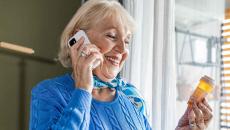 Person on phone holding pill bottle