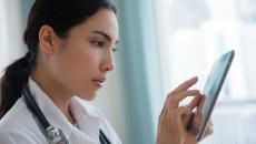 Female doctor reviews information on a tablet