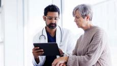 Doctor showing tablet to a patient