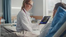 Healthcare worker showing tablet to patient