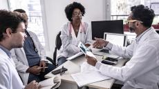 Doctors sitting at a desk and discussing data