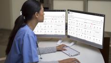 Healthcare worker working on a computer with dual monitors