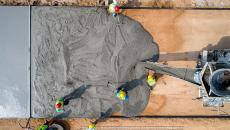 Workers lay out a layer of cement on a foundation.