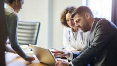 Doctor and businessperson looking at a laptop