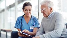 Doctor showing tablet to patient