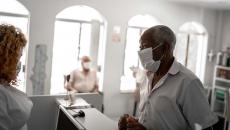 Patient in mask talking to healthcare worker in mask