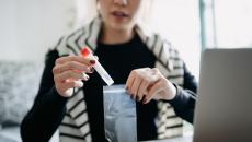 A person placing a medical test tube inside a plastic bag