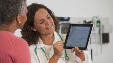 Doctor showing cardiogram on tablet to patient