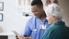 Doctor showing tablet to patient