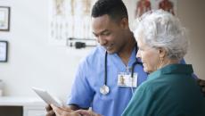 A nurse and a senior patient using a digital tablet