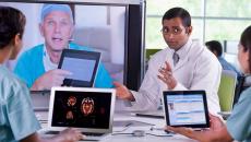 Doctors meeting with laptops and other doctor on a screen