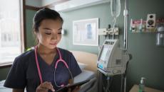 A doctor looking at a tablet. 