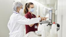 Physician and nurse at computer in hospital