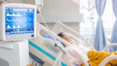 Patient in hospital bed with vital sign monitor