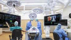 Surgery taking place with doctors working from digital monitors