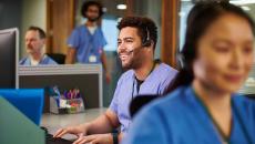 healthcare worker with headset using a computer