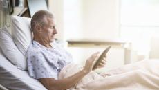 Patient in hospital bed using tablet