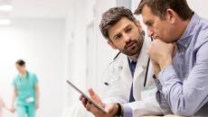 Doctor and person in shirt looking at tablet