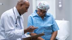 Doctor showing clipboard to cancer patient