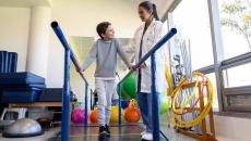 Healthcare worker working with child in physical therapy room