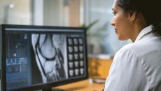 Healthcare worker looking at medical image on computer