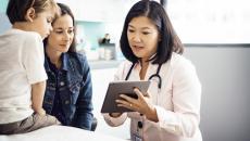 Doctor looking at tablet with patient