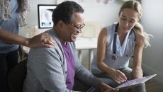 hospital doctor talking to patient with EHR tablet