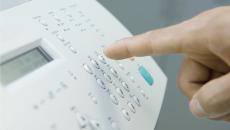 worker pressing button on fax machine