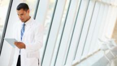 Doctor with tablet in hospital hallway