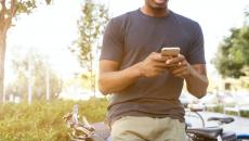 A person texting next to a bicycle