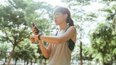 A person checking their smartwatch-tracked fitness data on their smartphone.