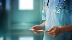 A medical professional using a tablet.