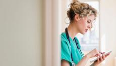 A nurse holding a digital tablet to check a patient's file