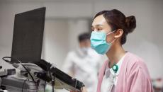 A nurse writing a medical record on a laptop