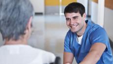 A nurse talking to a senior patient in a wheelchair