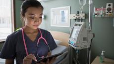 A nurse checking on a patient's file on a digital tablet