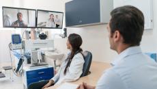 A doctor and their patient in a video conference with other specialists